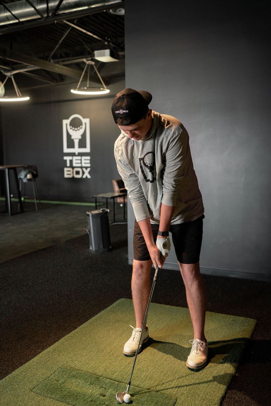 A man using a golf simulator in at Tee Box.