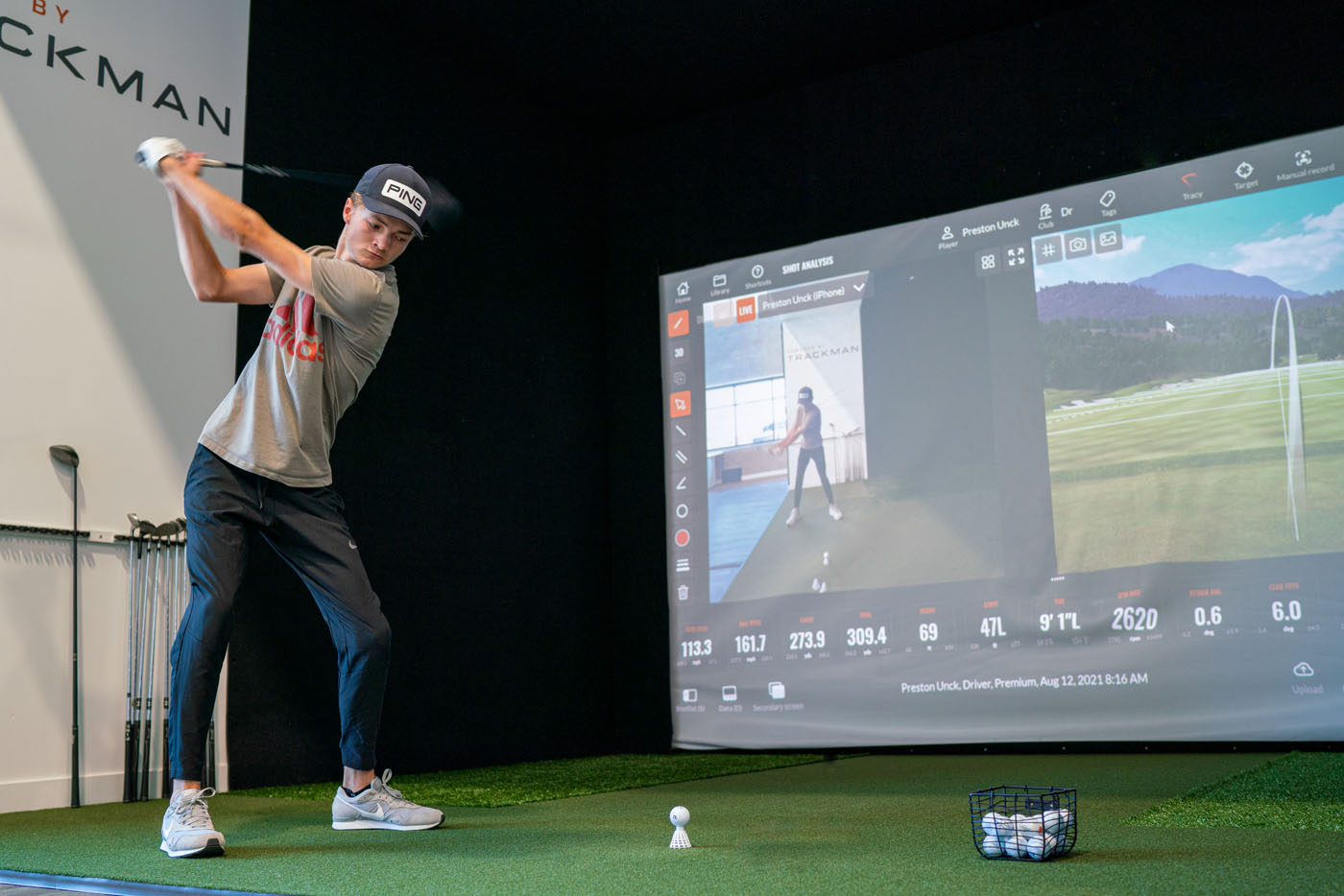 A young player at Tee Box practicing their swing with the best golf simulators.